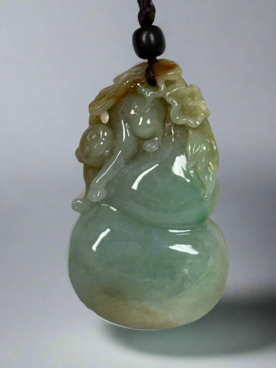 Green jade pendant with a animal figure on a white background