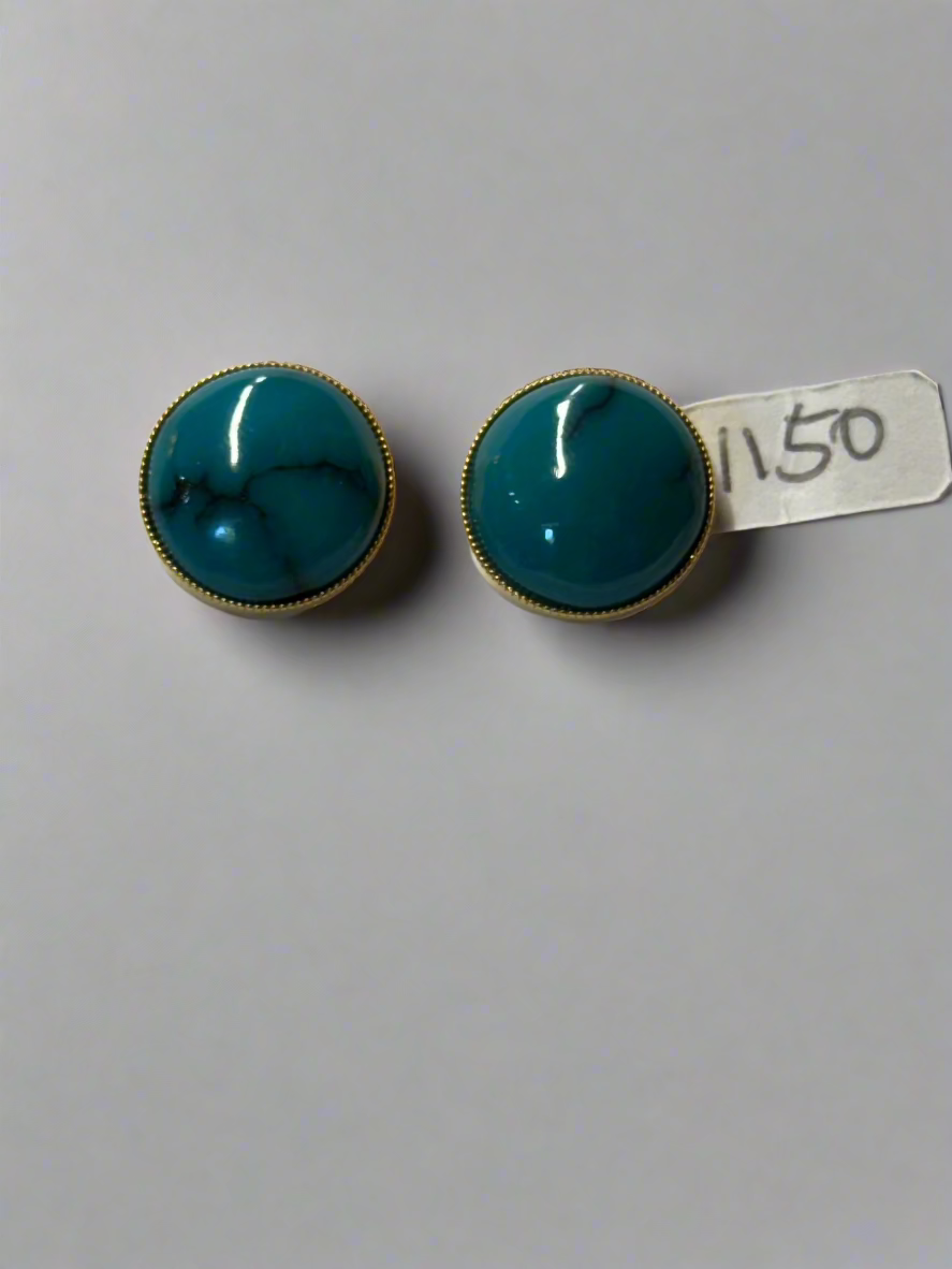 Pair of turquoise earrings with gold accents on a gray background