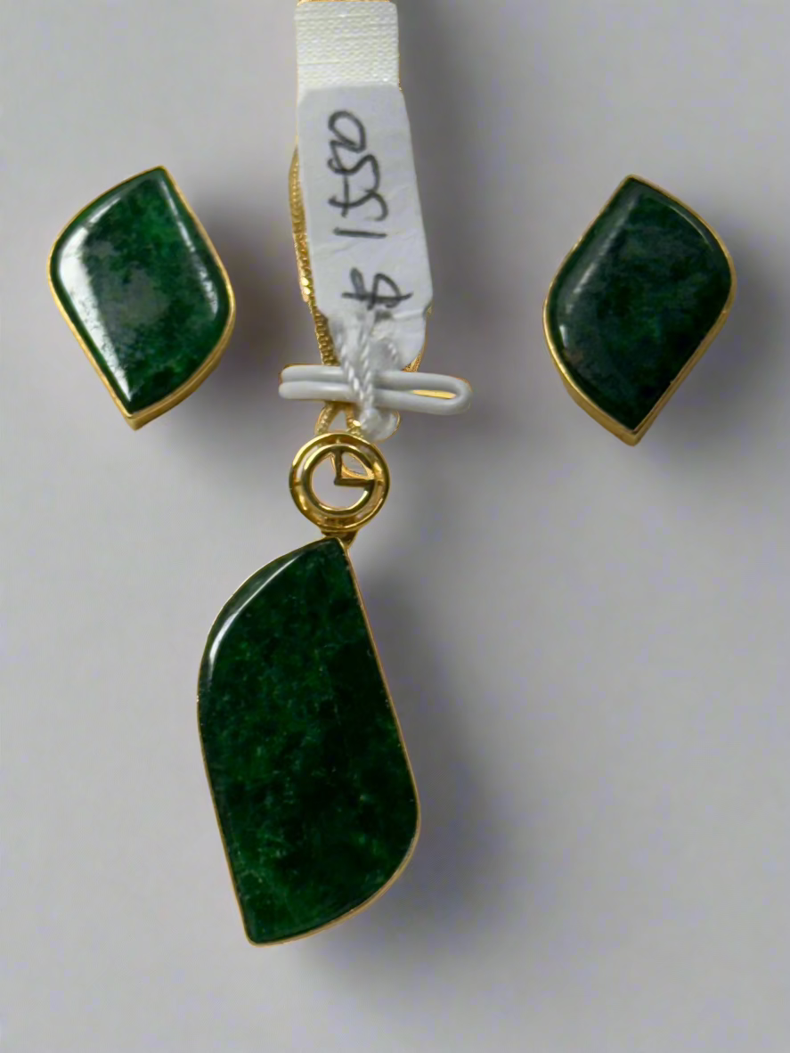 Jewelry set with green stones and gold accents on a white background
